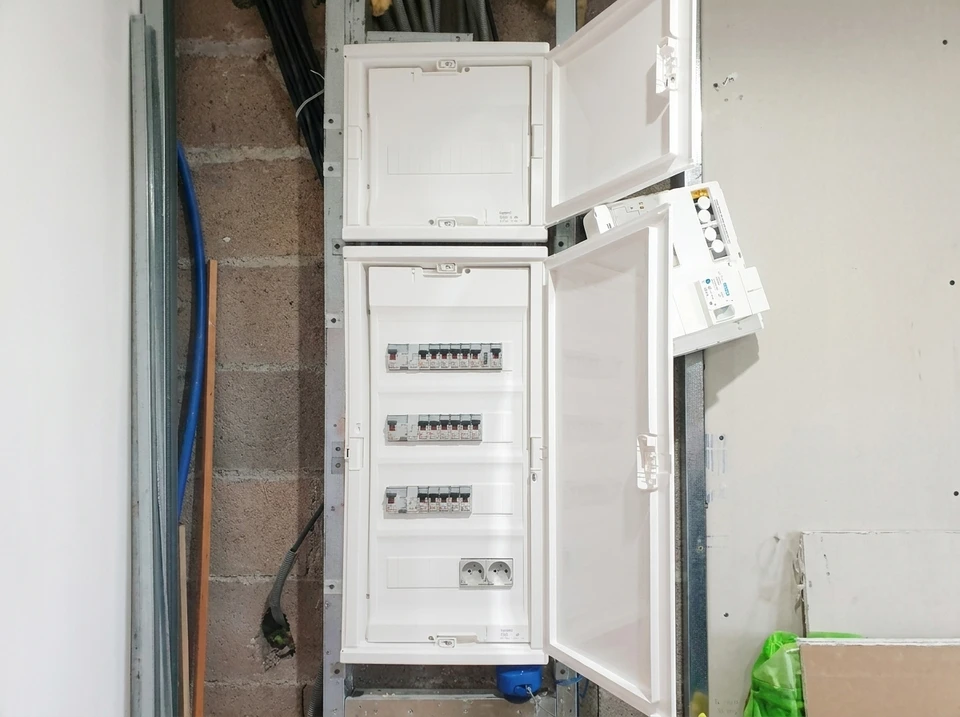 Tableau électrique résidentiel ouvert, fixé au mur intérieur, composé de trois modules empilés