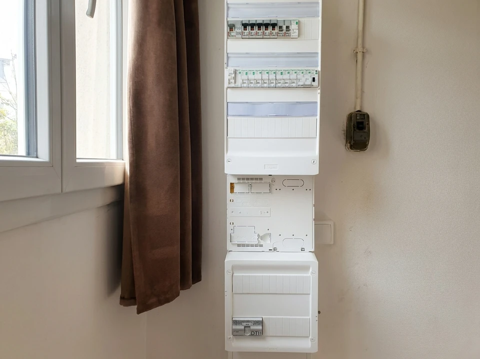 Tableau électrique résidentiel ouvert, fixé au mur intérieur, composé de trois modules empilés