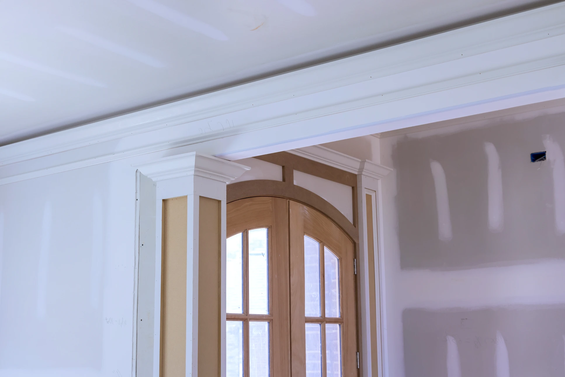Chantier de rénovation intérieure avec ouvrier en bleu travaillant dans une pièce en cours d'aménagement