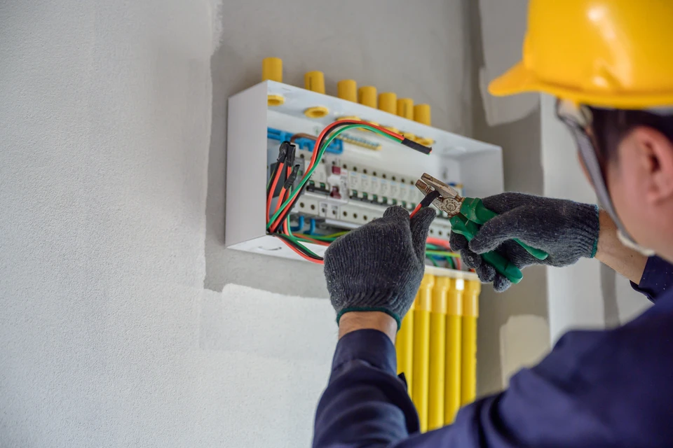 Chantier de construction résidentielle en cours avec ouvriers travaillant sur une maison à deux niveaux